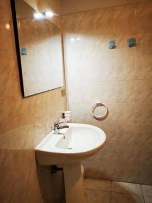 A bathroom with a white sink, a mirror, and a toilet. - Villasimius City Center (Villasimius)
