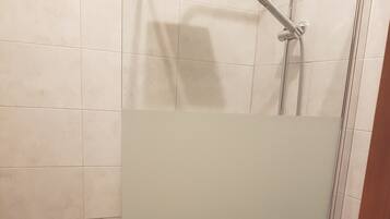 Een bad/douchecombinatie, een haardroger, een bidet, handdoeken