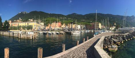 Experience the serene waterfront charm of this picturesque coastal town, surrounded by a marina and majestic mountains.