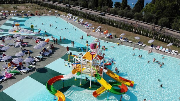 Una gran piscina al aire libre con varias toboganes y tumbonas.