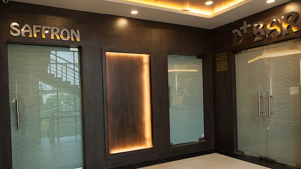 A modern interior with glass doors labeled "SAFFRON" and "D+BAR". - Hotel RG Inn (Jaipur)