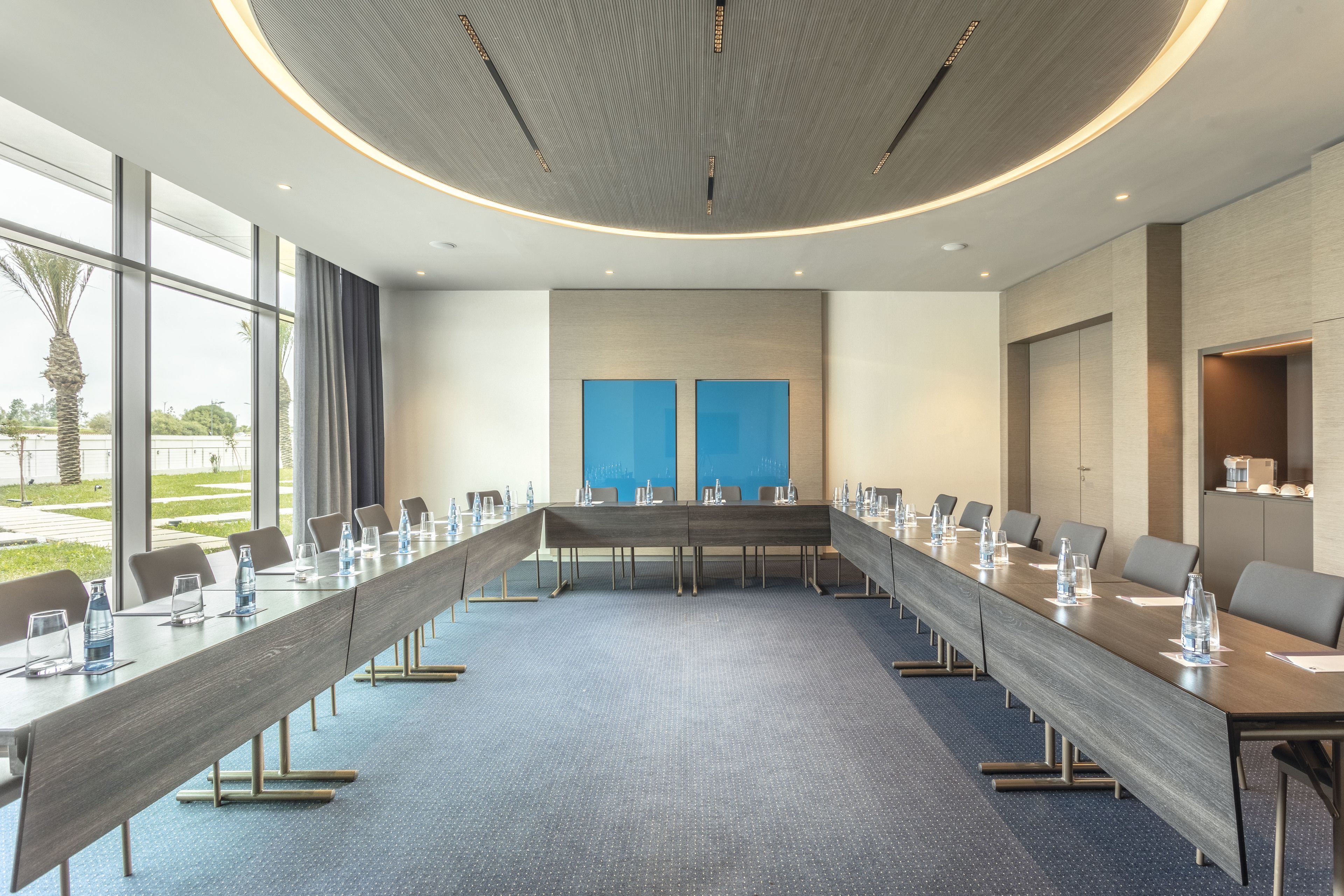 A conference room with a long table, chairs, and water bottles.