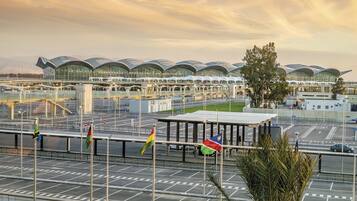 Una terminal aeroportuaria moderna con varias cubiertas curvas y un pasillo cubierto.
