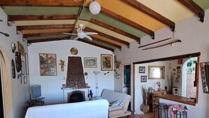 A cozy room with a bed, a dining table with chairs, a fireplace, and various wall decorations.