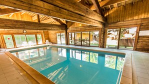 Ein Hallenbad mit Holzbalken und großen Fenstern.