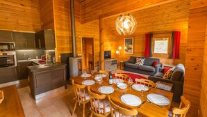 Ein gemütliches Blockhaus-Interieur mit Essbereich, Küche und Wohnbereich.