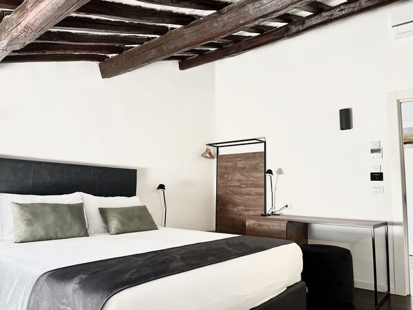 Une chambre d’hôtel moderne avec un lit, une table de chevet, une lampe et un mur décoratif en bois.
