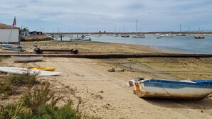 Une plage avec des bateaux, un rivage sablonneux et un ciel dégagé.