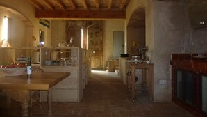 Une cuisine rustique avec des poutres en bois, un mur en pierre et une cheminée.