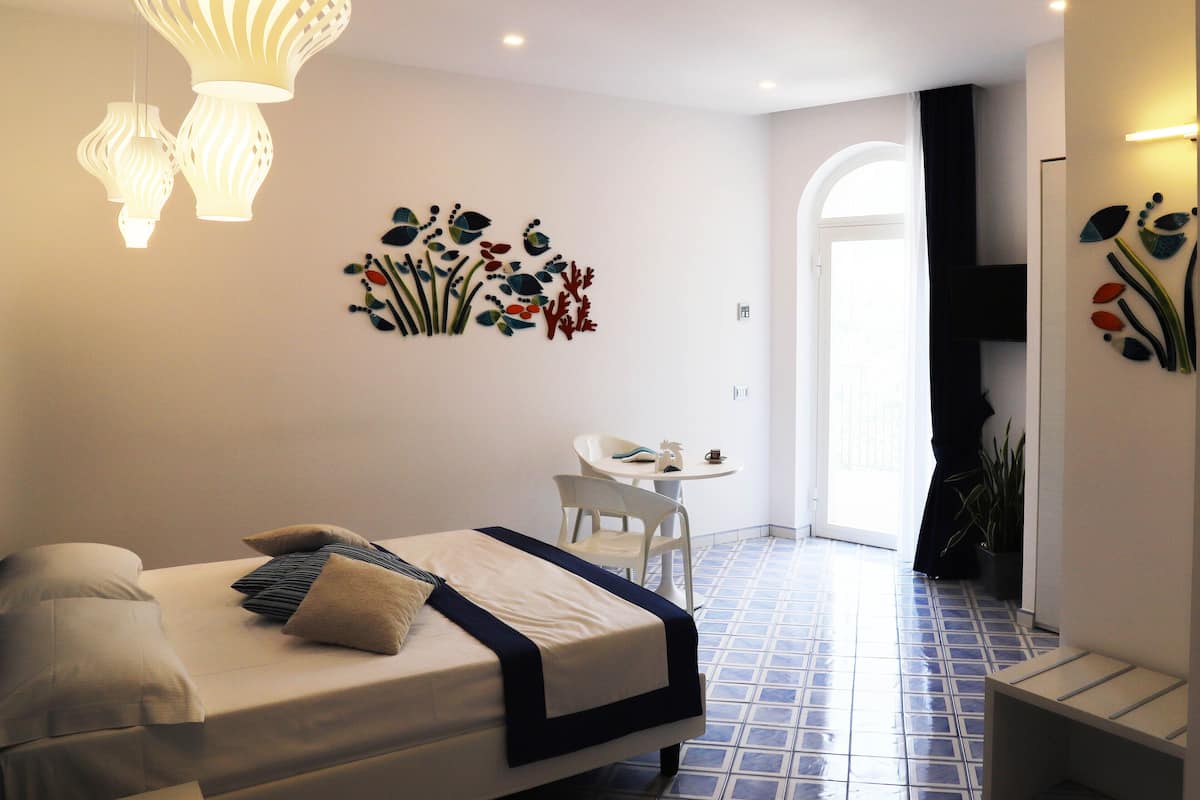 A modern hotel room with a bed, a small table, and decorative wall art.