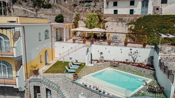 Una piscina al aire libre de temporada, sombrillas