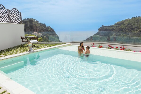 Una piscina al aire libre de temporada, sombrillas