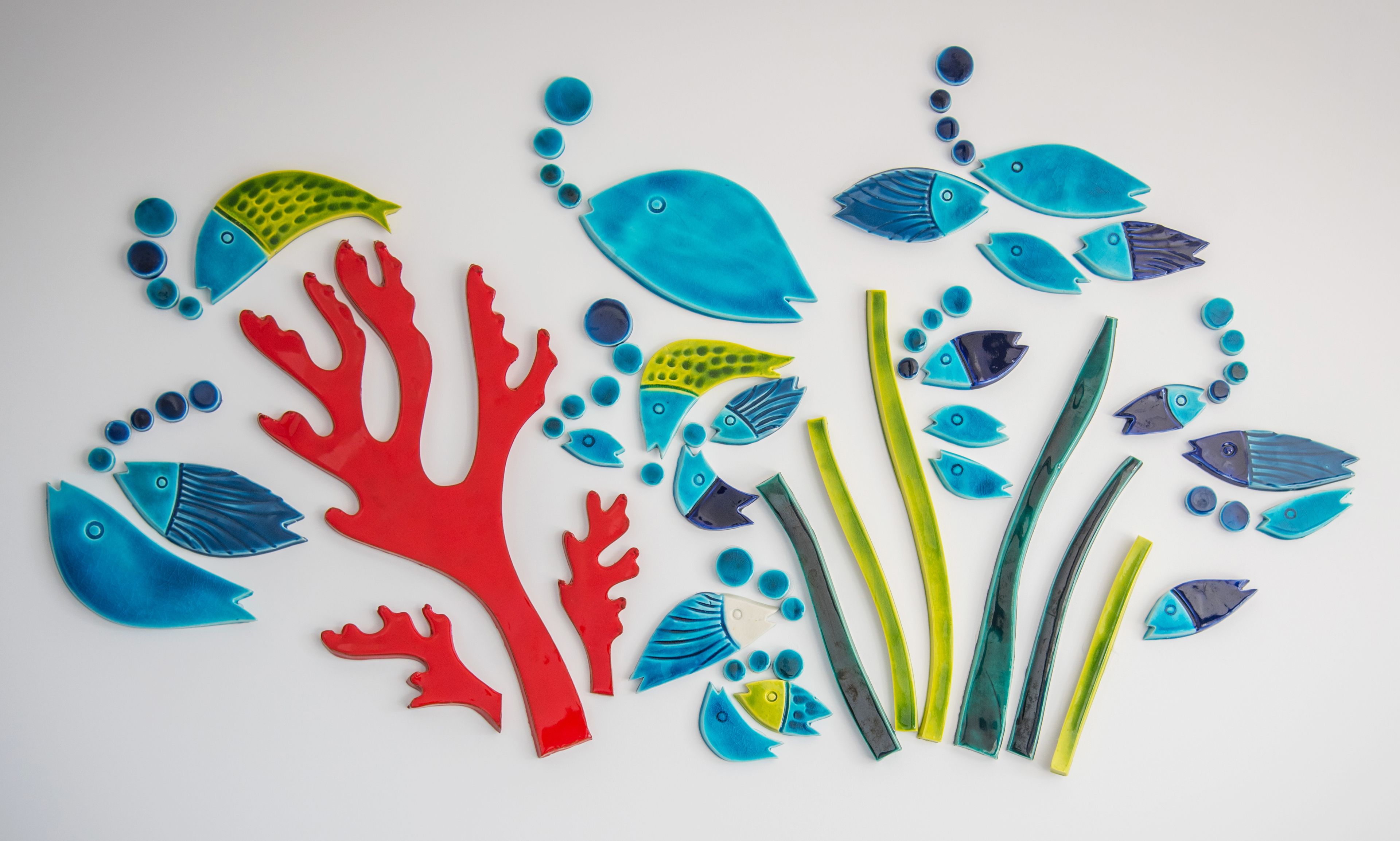 A collection of colorful fish and coral cutouts arranged on a white background.