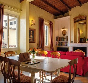 A dining area with a table, chairs, and a vase of flowers.