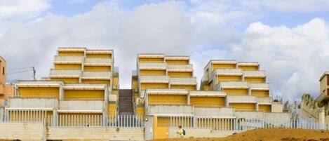 Een meerlaags gebouw met een gelijkmatige architectuur, voorzien van een reeks balkons en een plat dak.