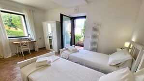 Habitación de hotel con dos camas, un escritorio y una silla.