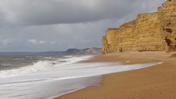 A beach with a sandy shore and a cliff. - The Brambles - one bedroom Country Cottage near Dorset Coast. (Weymouth)