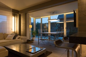 Un salon moderne comprenant un canapé, une table basse et un coin repas avec des chaises et une table.