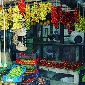 A market stall with various fruits like apples and grapes displayed in baskets and crates. - Agriturismo Castanito (Vico Equense)