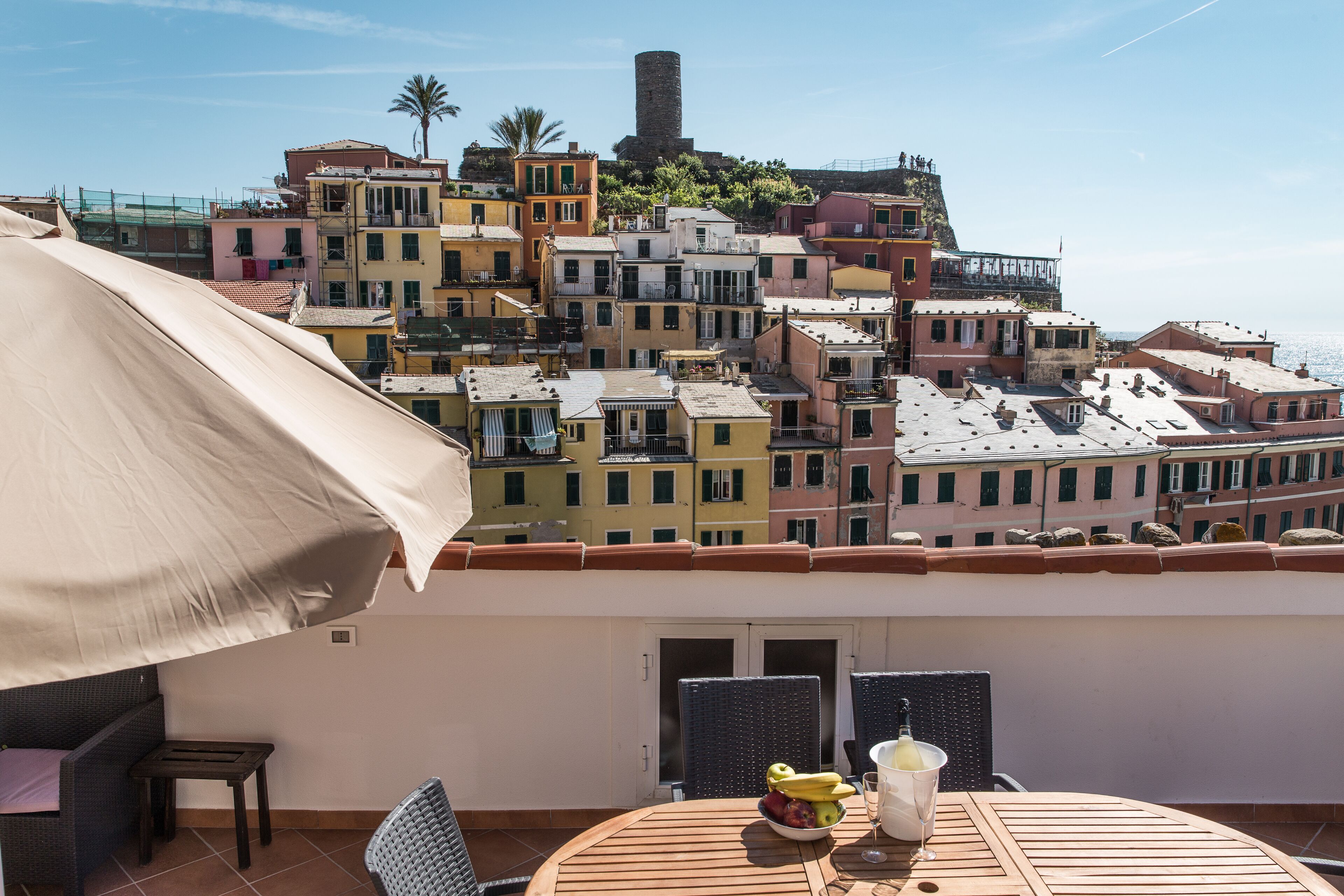 Ein Balkon mit Tisch, Stühlen und Sonnenschirm.