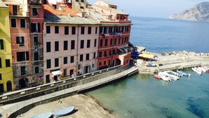 Un pueblo costero con edificios coloridos, un puerto deportivo y barcos amarrados.