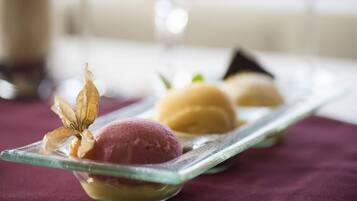 Un plato de postre con tres bolas de helado y una hoja decorativa.