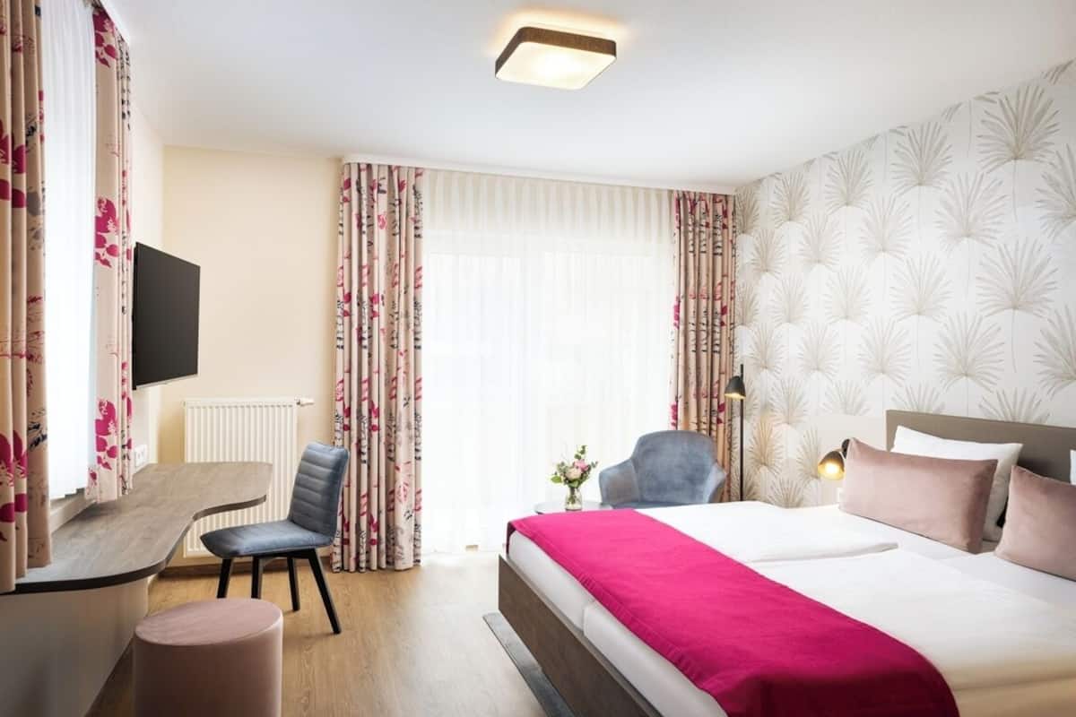 Ein Hotelzimmer mit einem Bett, einem Schreibtisch und einem Stuhl.