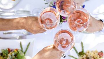 A group of people toasting with wine glasses at a table with white tablecloths and floral centerpieces.