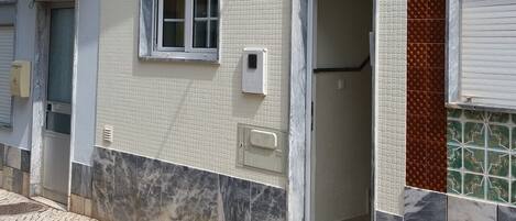 Un bâtiment à deux étages doté d’un balcon, d’une porte de garage et d’une façade recouverte de carreaux.