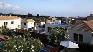 A residential area with houses, some with flat roofs and others with sloped roofs, under a clear sky. - Detached Villa In Cul-de-Sac With Private Pool And Sea Views & Free WiFi. (Peyia. Paphos)