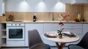 Una cucina moderna con forno a incasso, lavello e zona pranzo con tavolo rotondo e sedie.
