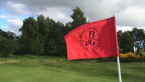 A red flag with the text "Boat of Garten Golf Club" and the year "1898" on a golf course.