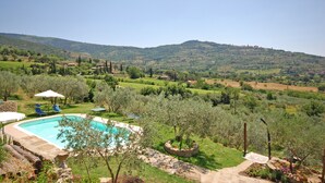 Una piscina rodeada de exuberante vegetación y un paisaje montañoso.