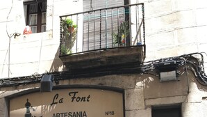 Ein Schaufenster mit einem Metallgitter und einem Schild, auf dem 'La Font Artesania No 18' steht.