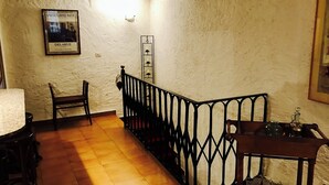Eine Treppe mit schwarzer Geländer, ein Holzstuhl und ein Tisch mit Tablett.