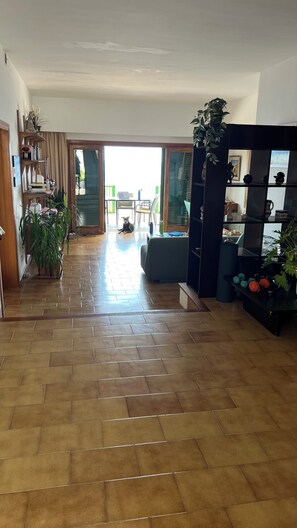 A spacious living area with a tiled floor, a sofa, a coffee table, and a bookshelf. - Exclusive Seafront Villa with Pool & Panoramic Views (Santa Ponça)