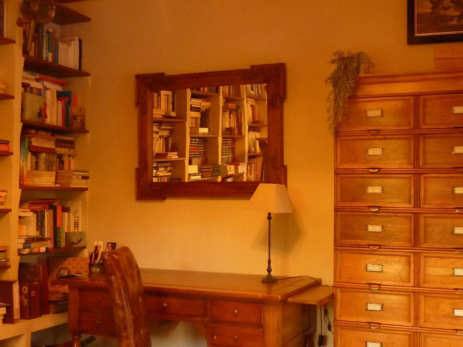 Une salle d’étude équipée d’un bureau en bois, d’étagères, d’un miroir et d’un classeur.