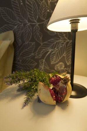 A pomegranate on a table with a lamp and a patterned wall in the background. - B&B Croara (San Lazzaro di Savena)