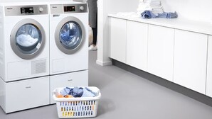 A front-loading washer and dryer unit with a basket of laundry.