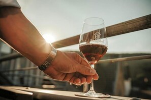 A hand holding a wine glass with the inscription "HR Rooderhof" on a balcony railing. - Rodderhof (Bad Neuenahr-Ahrweiler)