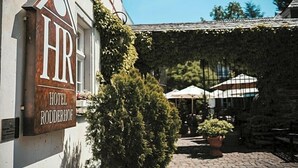 A hotel sign with the name "HOTEL RODDERHOF" and a courtyard with potted plants and umbrellas. - Rodderhof (Bad Neuenahr-Ahrweiler)