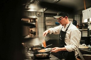 A chef in a professional kitchen preparing food. - Rodderhof (Bad Neuenahr-Ahrweiler)