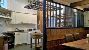 A kitchen with white cabinets, a stove, and a dining area with a table and chairs.