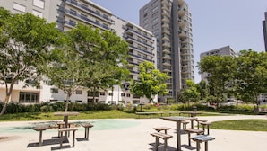 Un parque con mesas de picnic y una zona de juegos.