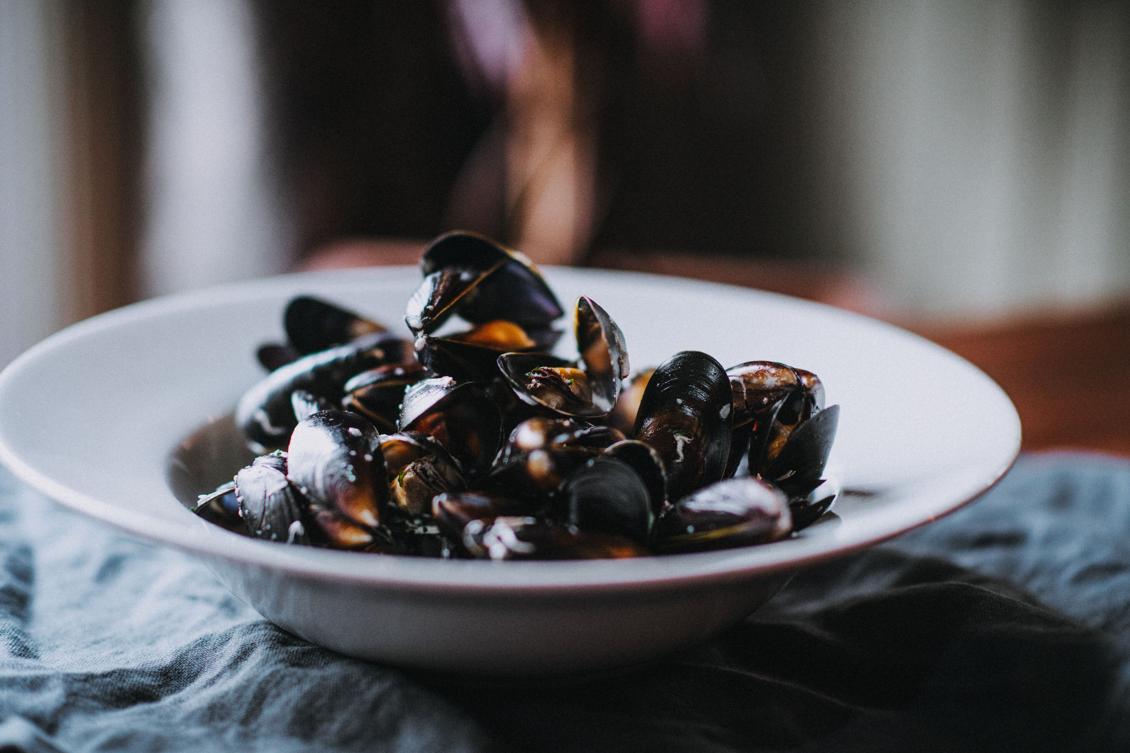Un plato con un bol de mejillones.