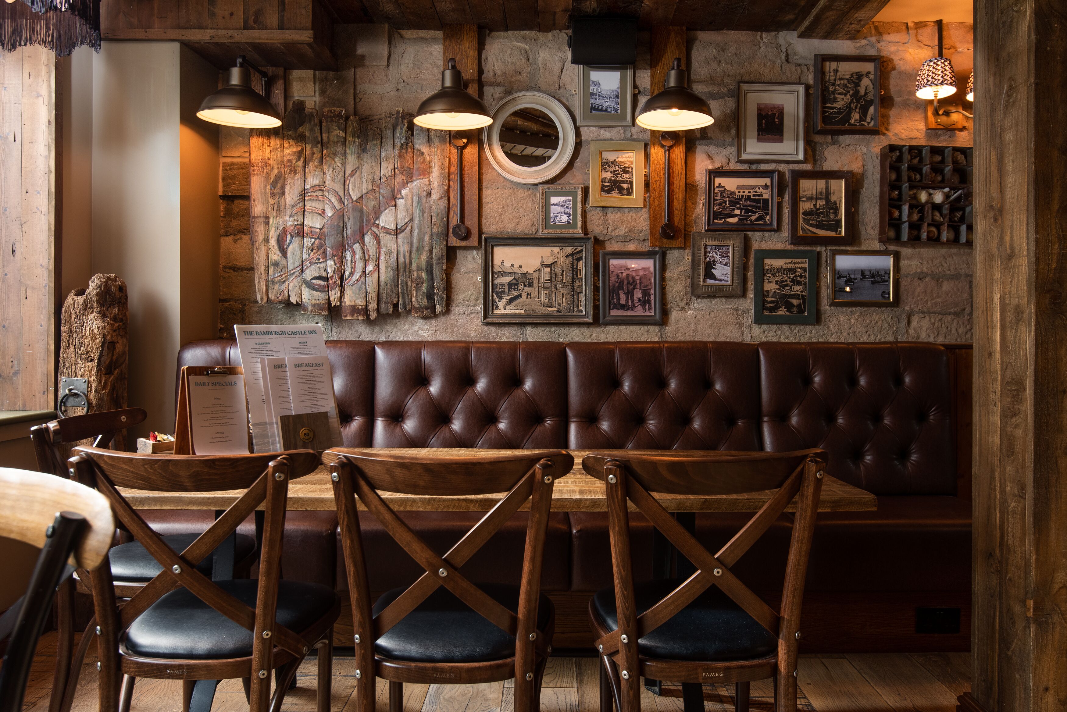 A cozy restaurant with a wooden interior, a leather booth, and framed pictures on the wall.