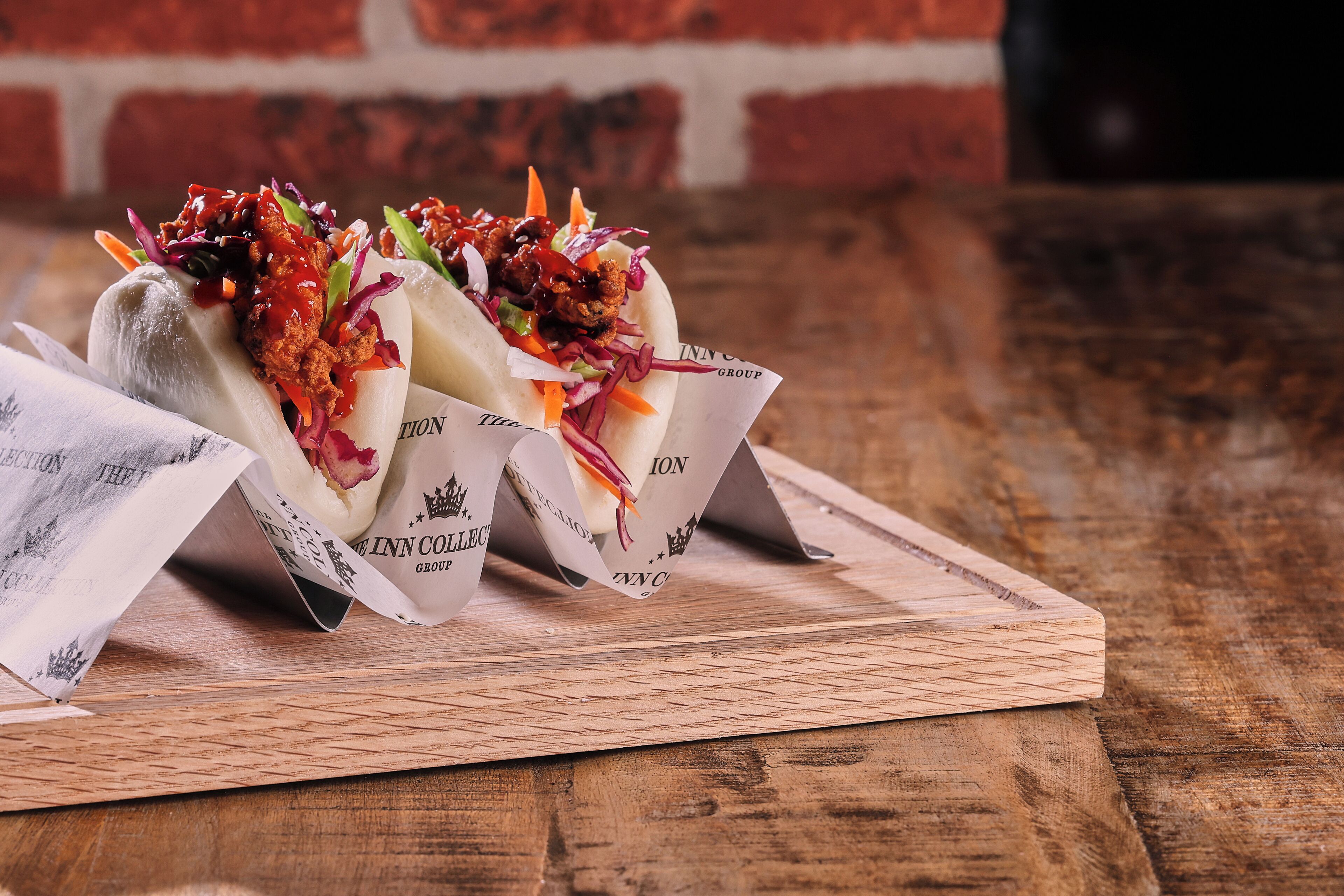 Two food items on a wooden board with a brick wall in the background.