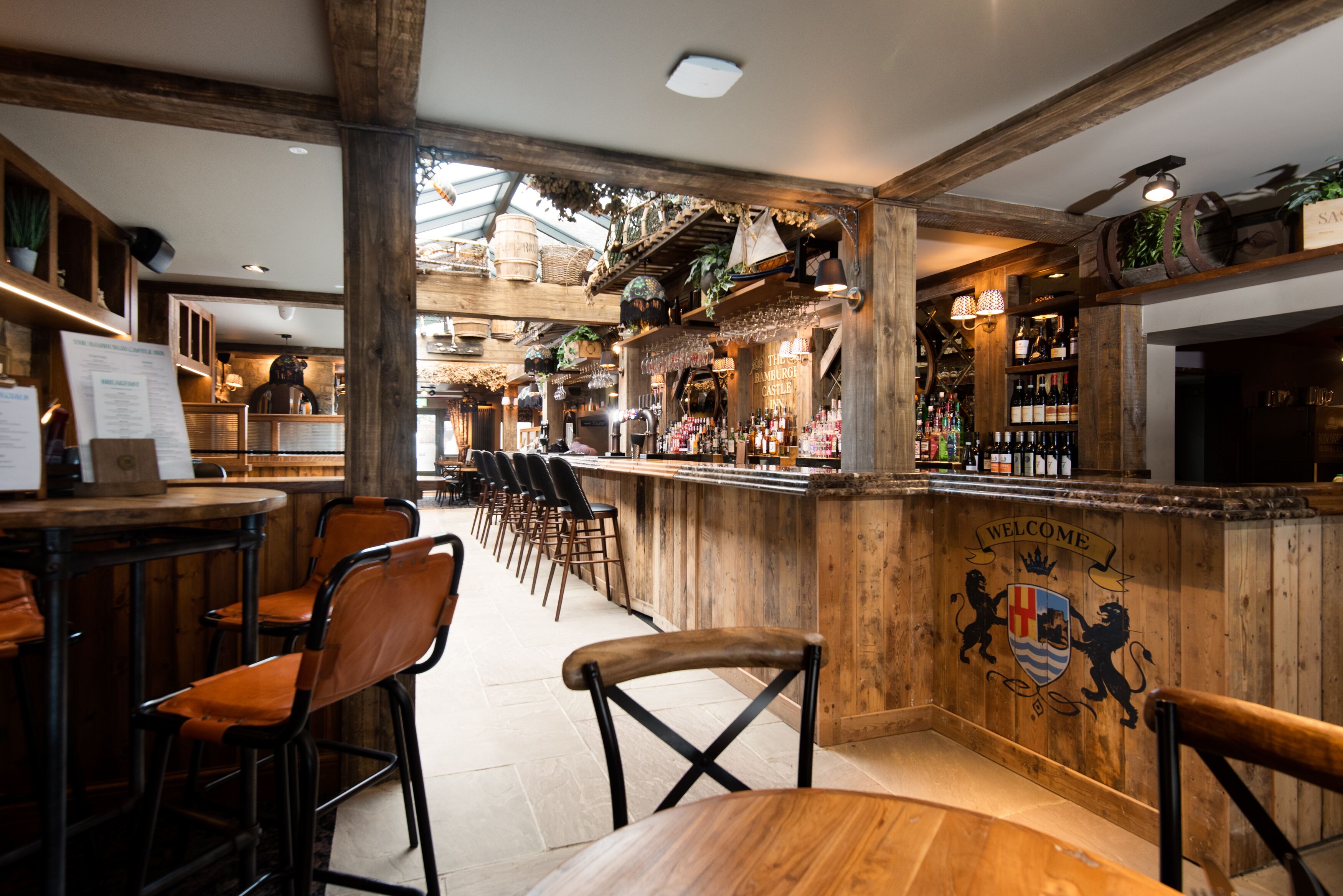 A bar area with wooden decor, a bar counter, and seating arrangements.