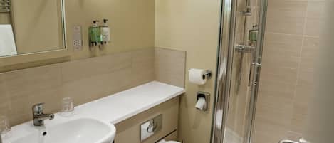 A bathroom with a sink, toilet, and shower.