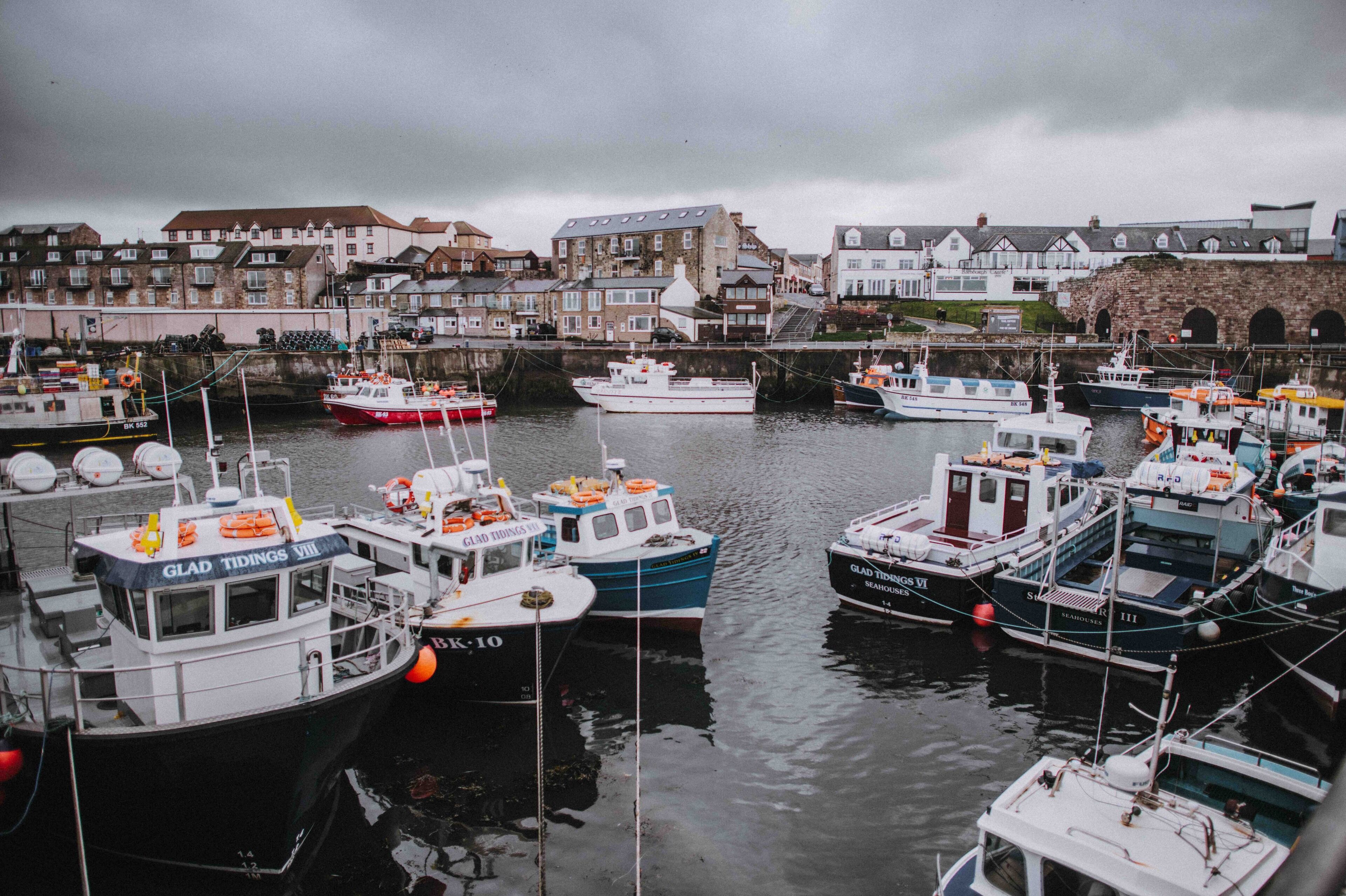 A marina with various boats docked, surrounded by buildings.